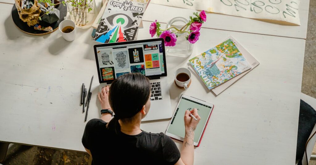 Artistic workspace featuring calligraphy and digital design on a tablet and laptop.