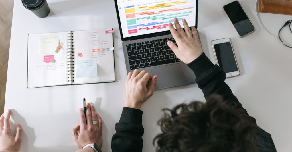 Two people collaborating on a laptop and planner at a vibrant modern office desk.